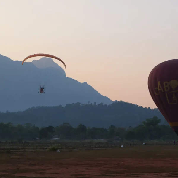 Paramoter und Heißluftballon beim Sonnenuntergang