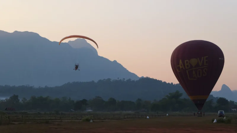 Paramoter und Heißluftballon beim Sonnenuntergang